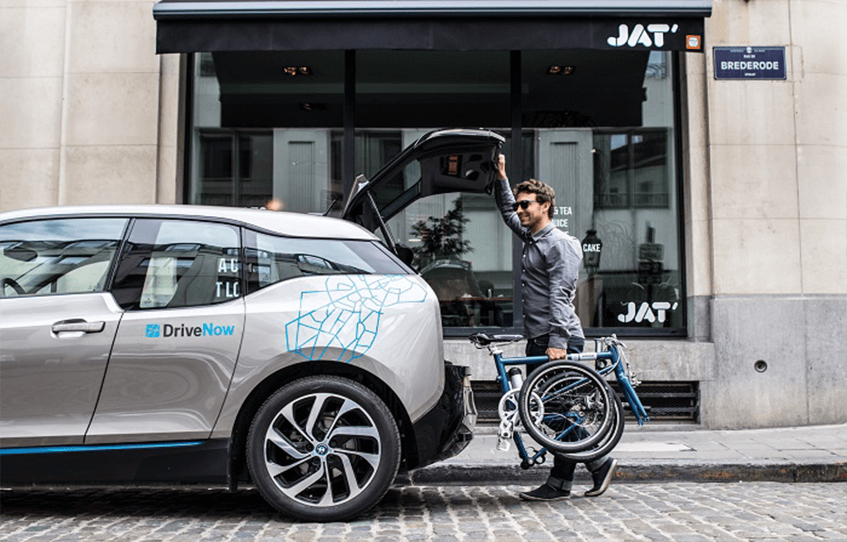 mann führt ahooga-faltrad im auto ein